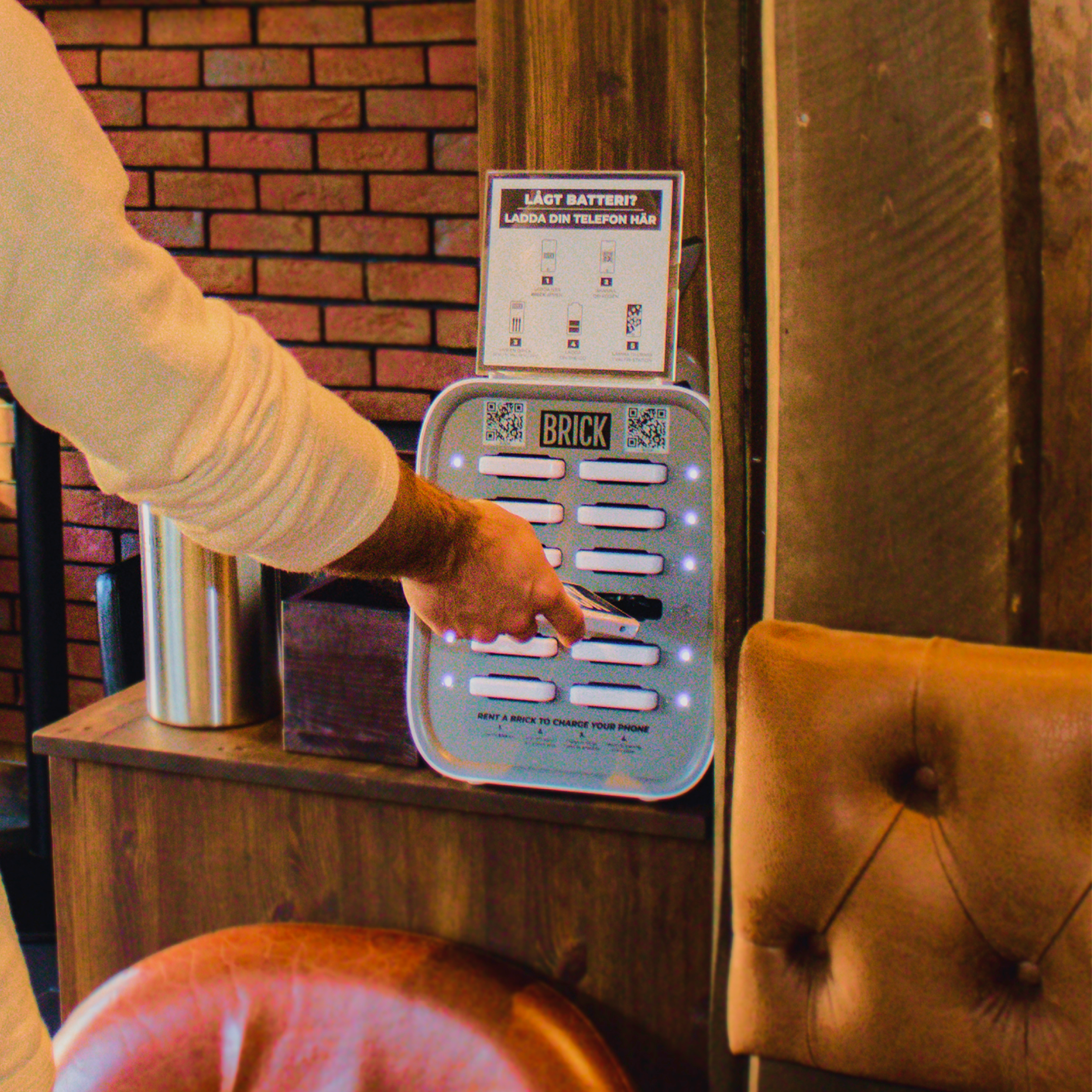 Hand putting in a Brick power bank in a Brick Medium 12 slot station